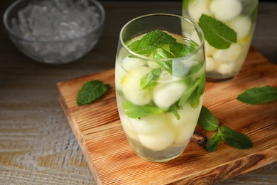 Tasty melon ball drink on wooden table, closeup