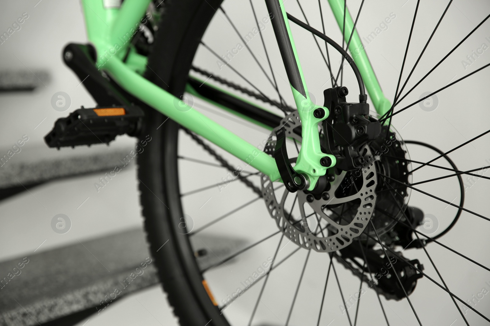 Photo of Modern green bicycle on stairs at home, closeup