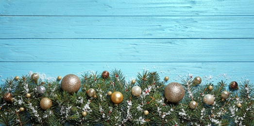 Photo of Fir tree branches with Christmas decoration on light blue wooden background, flat lay. Space for text