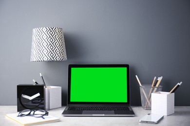 Laptop display with chroma key. Comfortable workplace in room