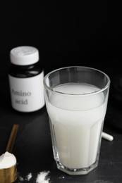 Photo of Amino acid shake and powder on black background