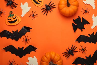 Flat lay composition with bats, pumpkins, ghosts and spiders on orange background, space for text. Halloween celebration