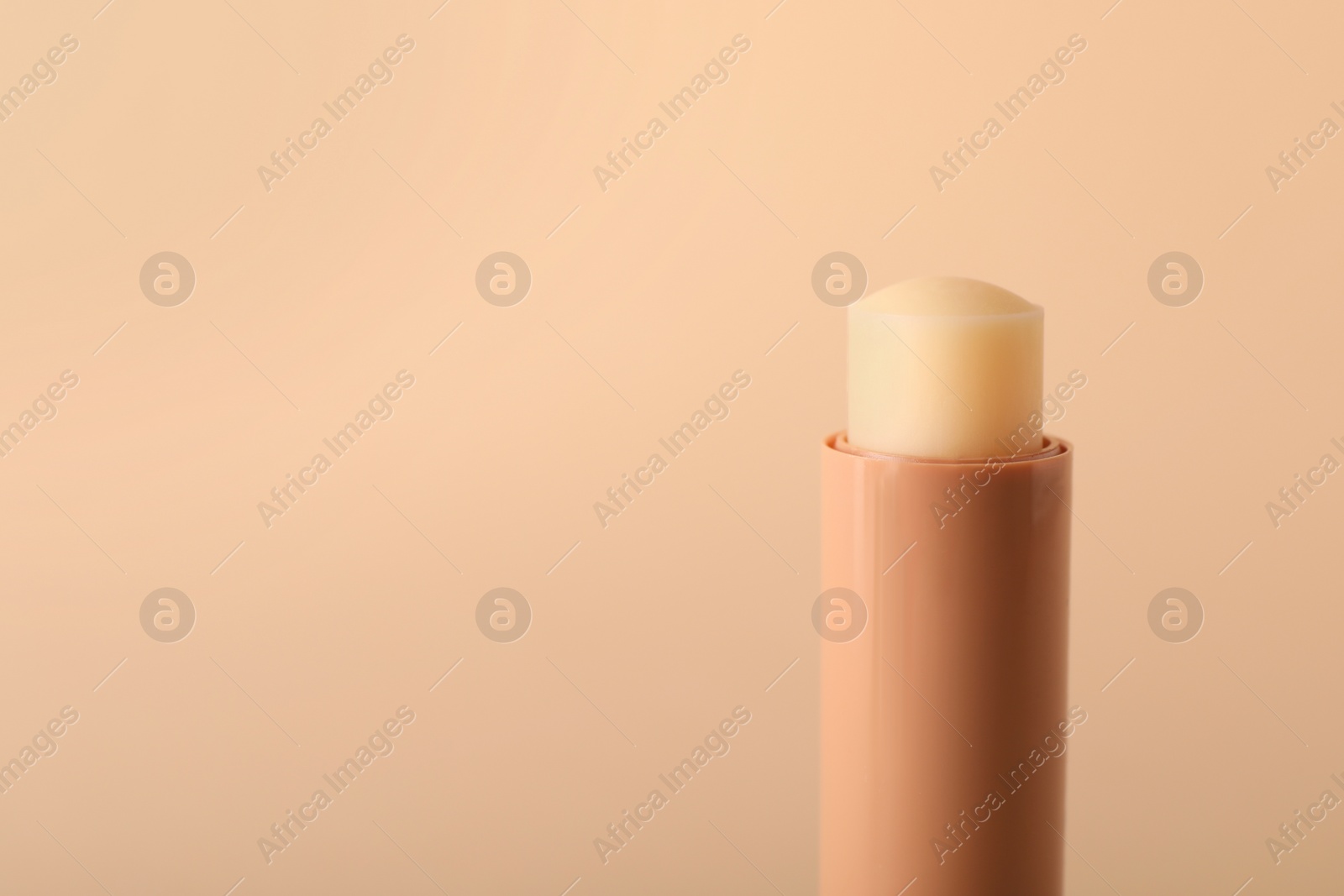 Photo of Lip balm on beige background, closeup. Space for text