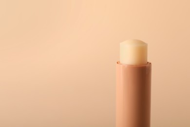 Photo of Lip balm on beige background, closeup. Space for text