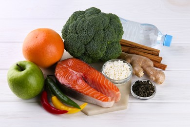 Photo of Metabolism. Different food products on white wooden table