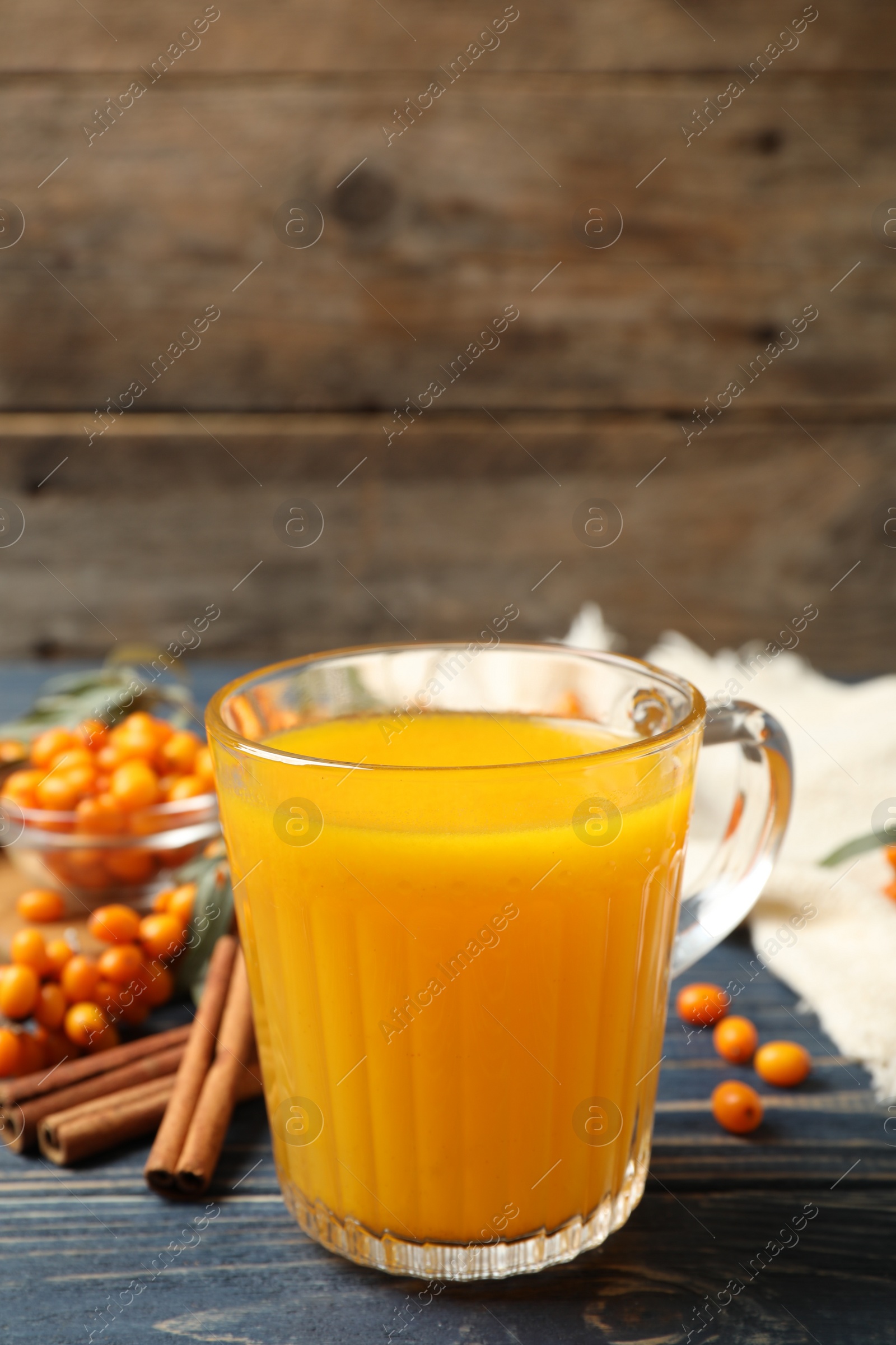 Photo of Fresh sea buckthorn tea on blue wooden table