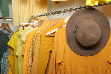 Different yellow clothes on hangers in wardrobe. Fashion blogger