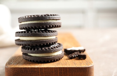 Board with chocolate cookies on table. Space for text