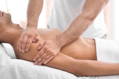 Young man receiving massage in salon, closeup