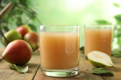 Fresh pear juice in glass on wooden table, closeup