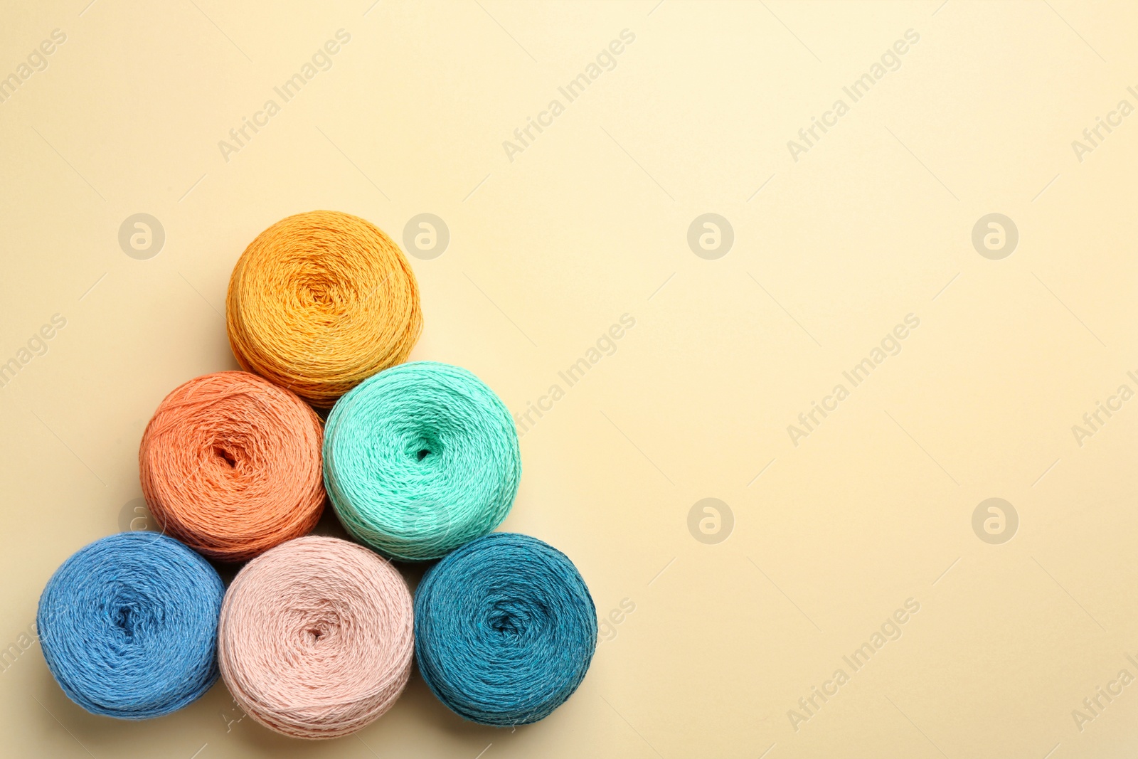 Photo of Clews of knitting threads on color background, flat lay with space for text. Sewing stuff