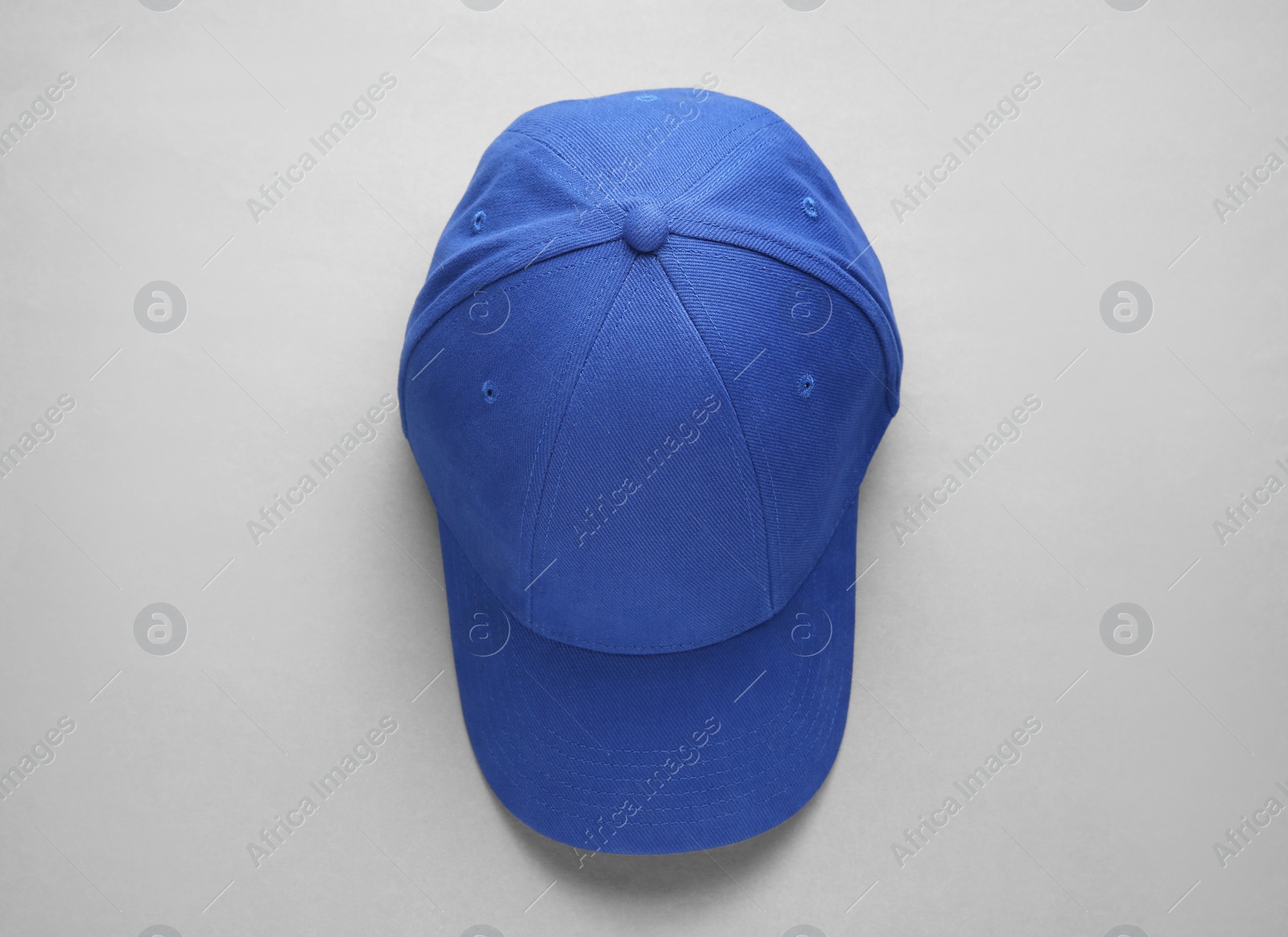 Photo of Stylish blue baseball cap on light grey background, top view