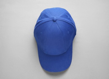 Photo of Stylish blue baseball cap on light grey background, top view