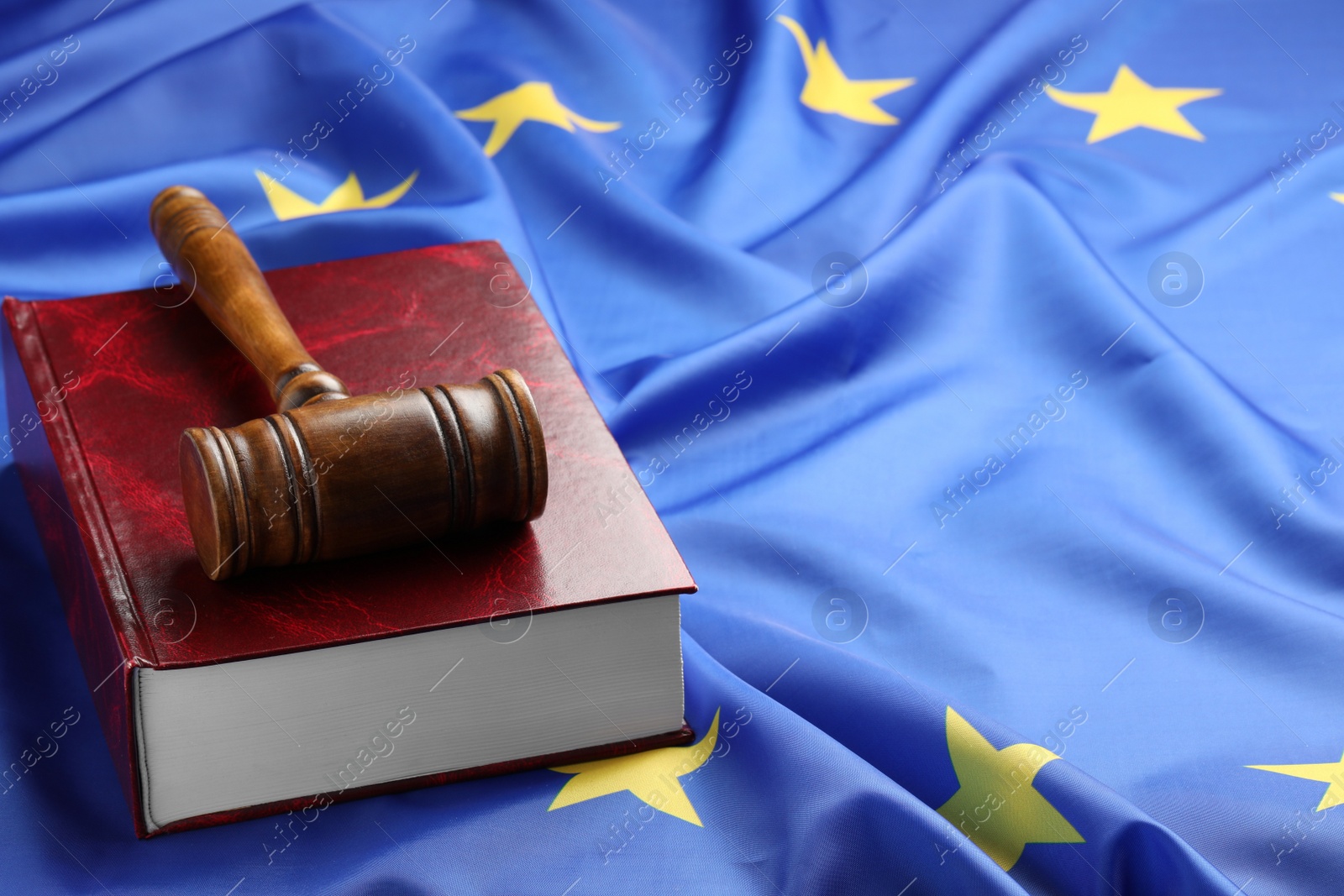 Photo of Wooden judge's gavel and book on flag of European Union, space for text