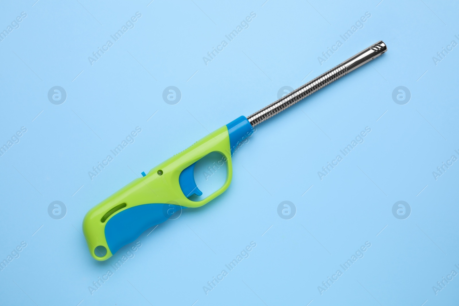 Photo of One gas lighter on light blue background, top view