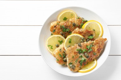 Photo of Delicious chicken piccata on white wooden table, top view