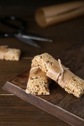 Tasty sesame seed bars on wooden table