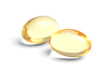 Photo of Cod liver oil pills on white background