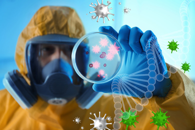 Scientist in chemical protective suit with Petri dish at laboratory, focus on hand. Virus research