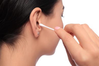 Young woman cleaning ear with cotton swab on white background, closeup