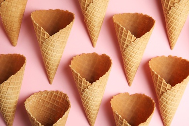 Photo of Empty wafer ice cream cones on pink background, flat lay