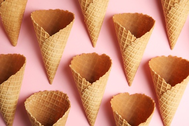 Empty wafer ice cream cones on pink background, flat lay