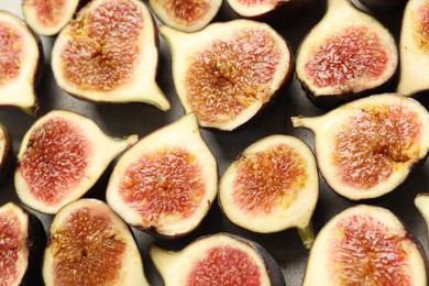 Photo of Delicious cut raw figs on light grey table, closeup