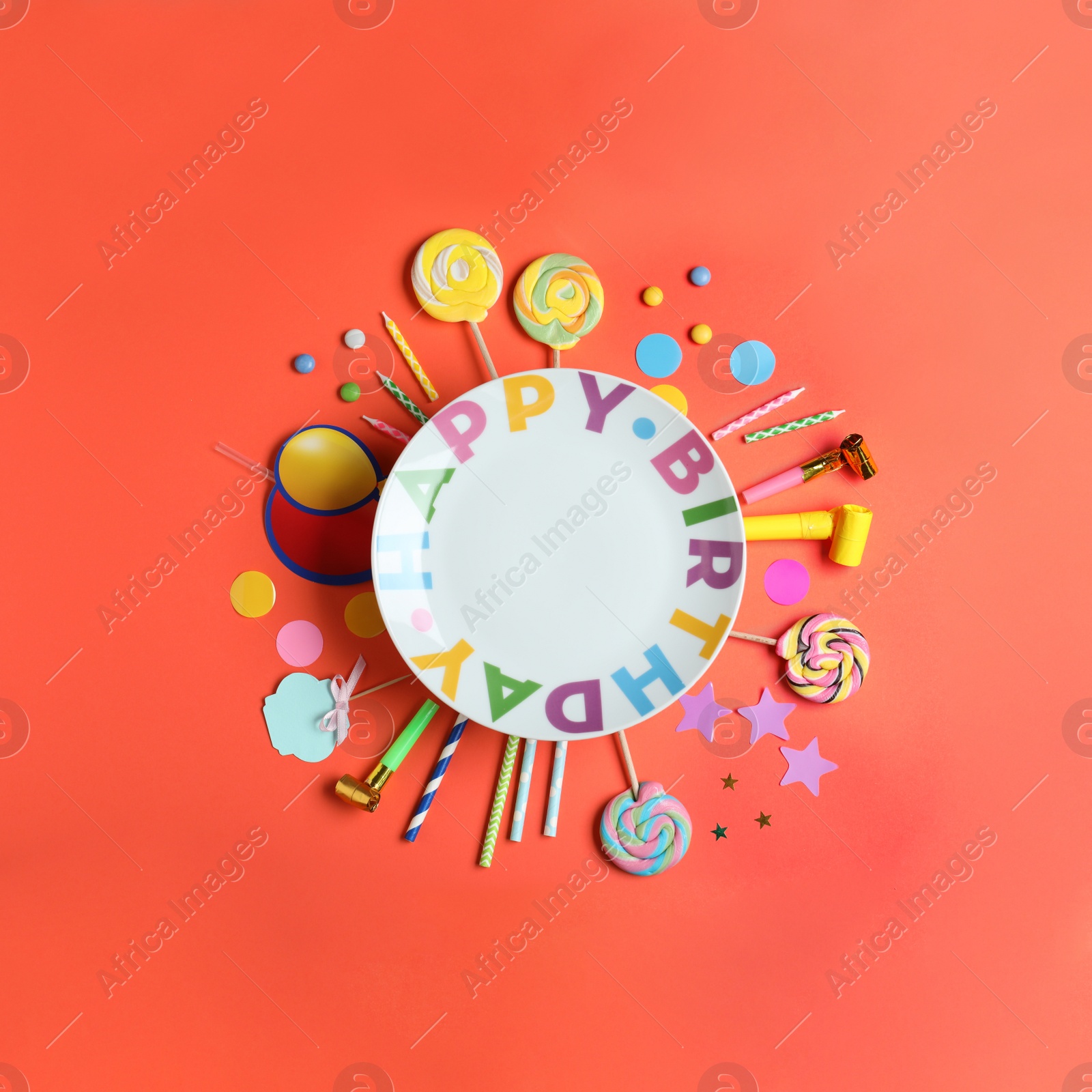 Photo of Different birthday party items and empty plate on coral background, flat lay. Space for text