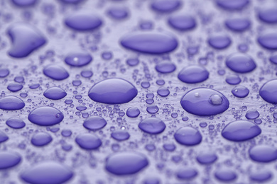 Water drops on lilac background, closeup view