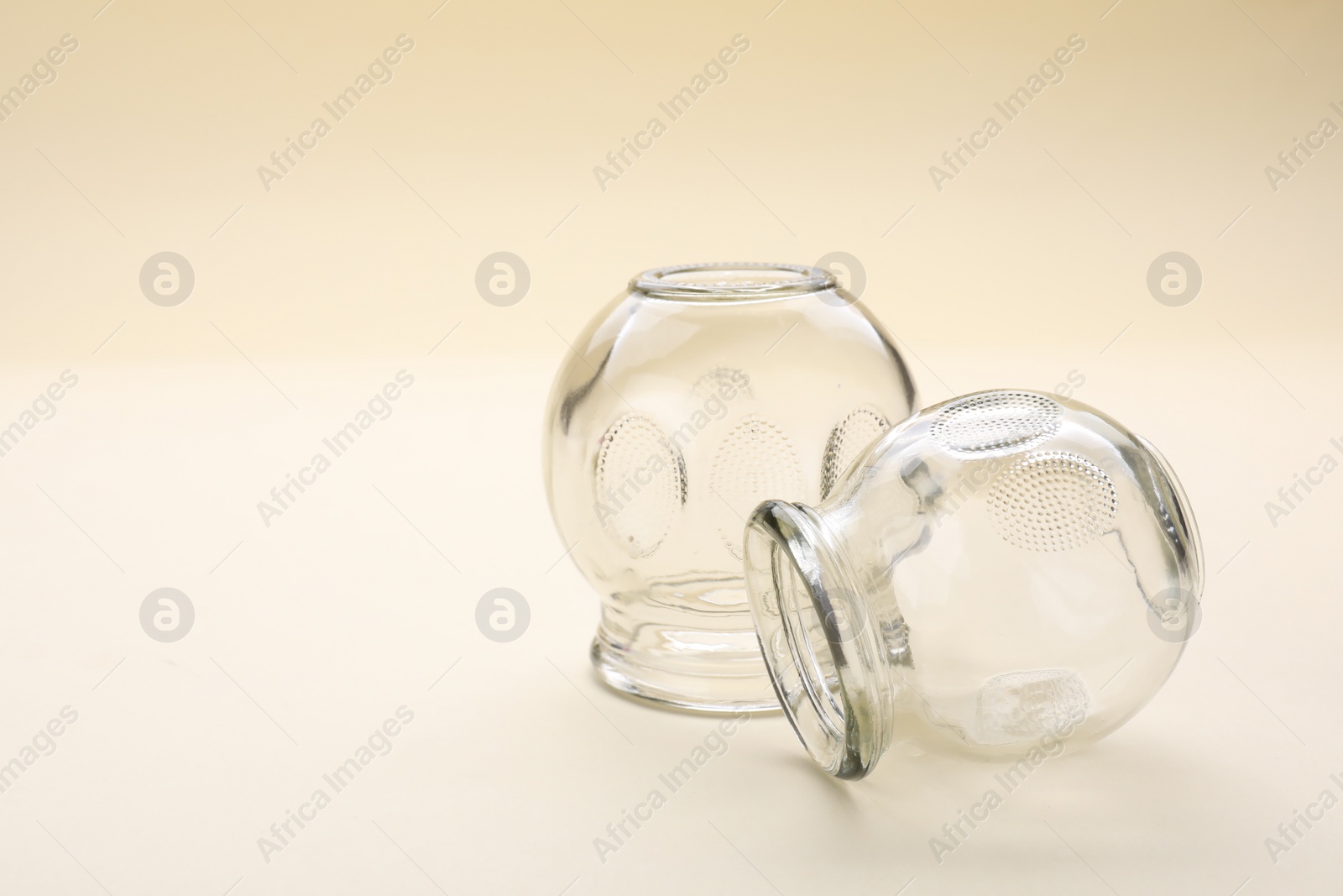 Photo of Glass cups on beige background, space for text. Cupping therapy