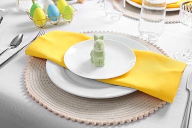 Festive table setting with cutlery, plate and bunny figure. Easter celebration