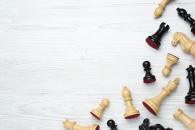 Photo of Many different chess pieces on white wooden table, flat lay. Space for text