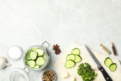 Photo of Pickling jar with fresh ripe cucumbers and spices on grey table, flat lay. Space for text