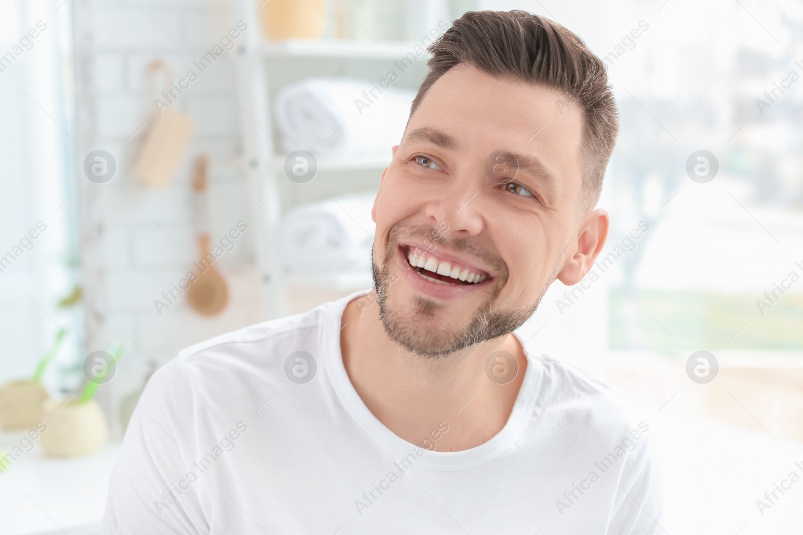 Photo of Young man with beautiful smile indoors. Teeth whitening