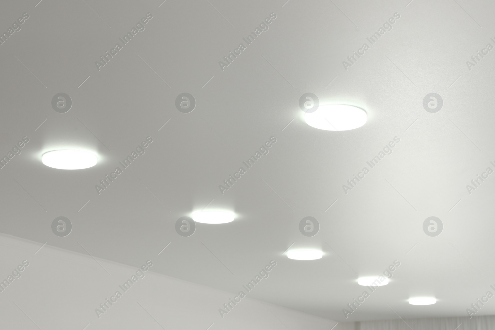 Photo of White ceiling with lamps indoors, below view