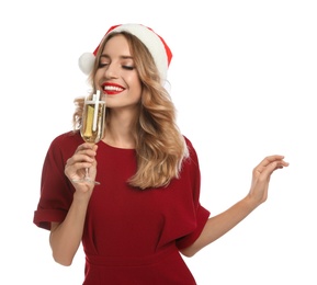 Photo of Happy young woman wearing Santa hat with glass of champagne on white background. Christmas celebration