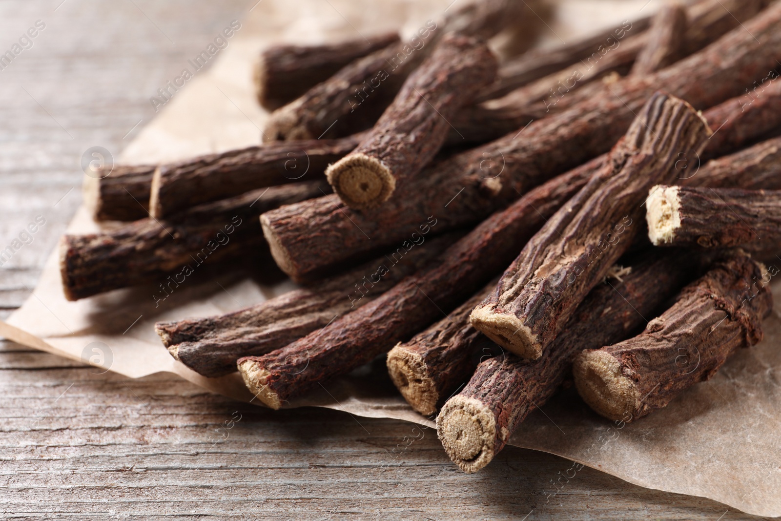 Photo of Dried sticks of liquorice root on wooden table, closeup