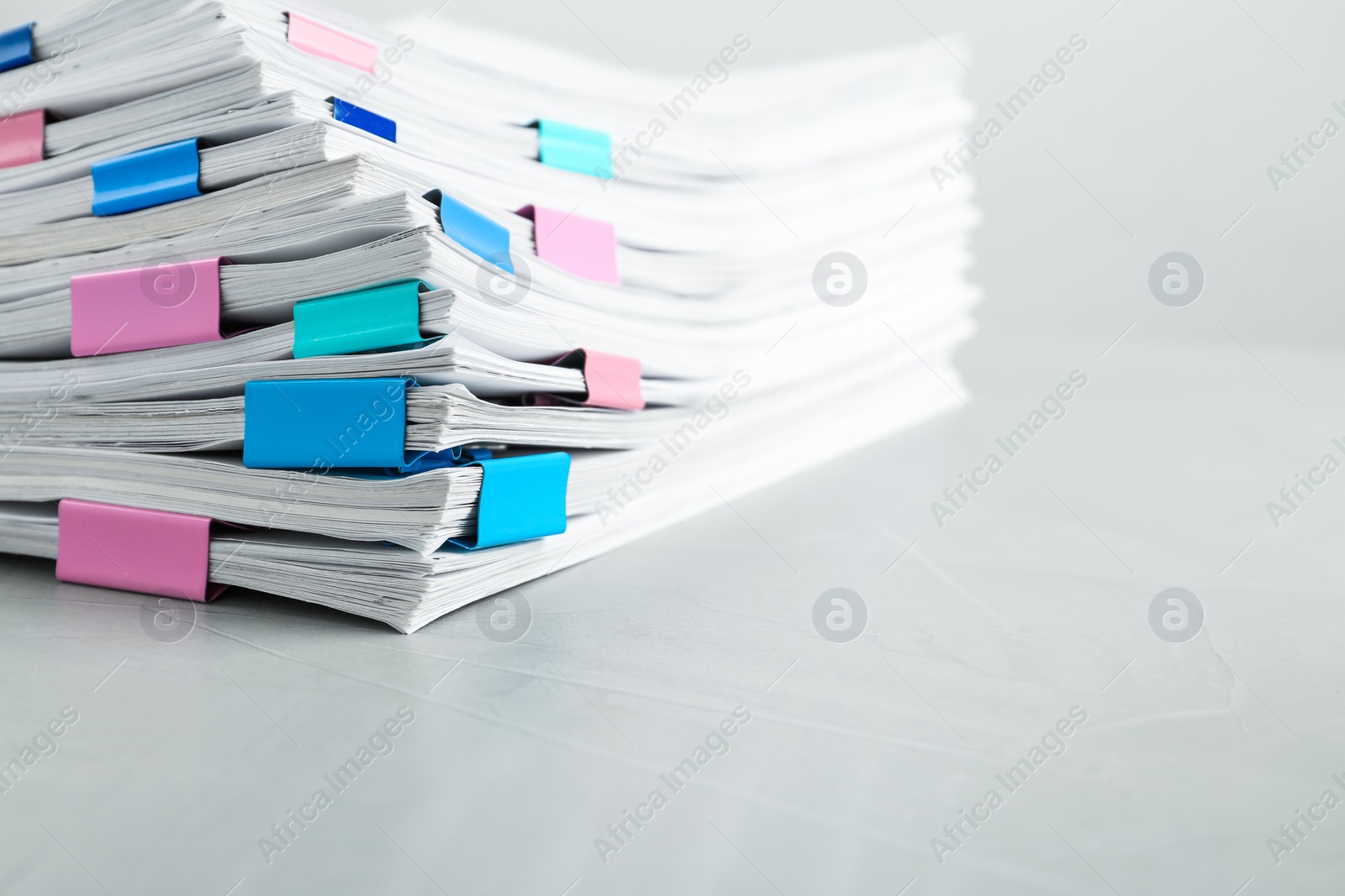 Photo of Stack of documents with binder clips on light table