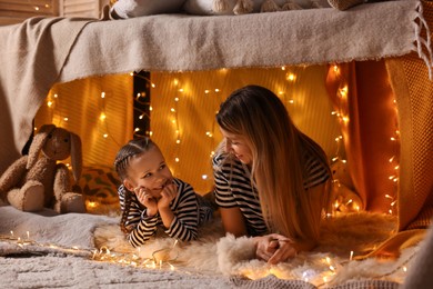 Photo of Mother and her daughter in play tent at home