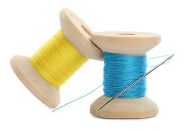 Photo of Colorful sewing threads with needle on white background, closeup