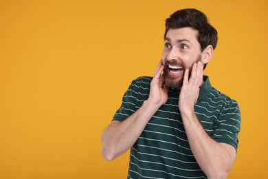 Photo of Portrait of surprised man on yellow background, space for text