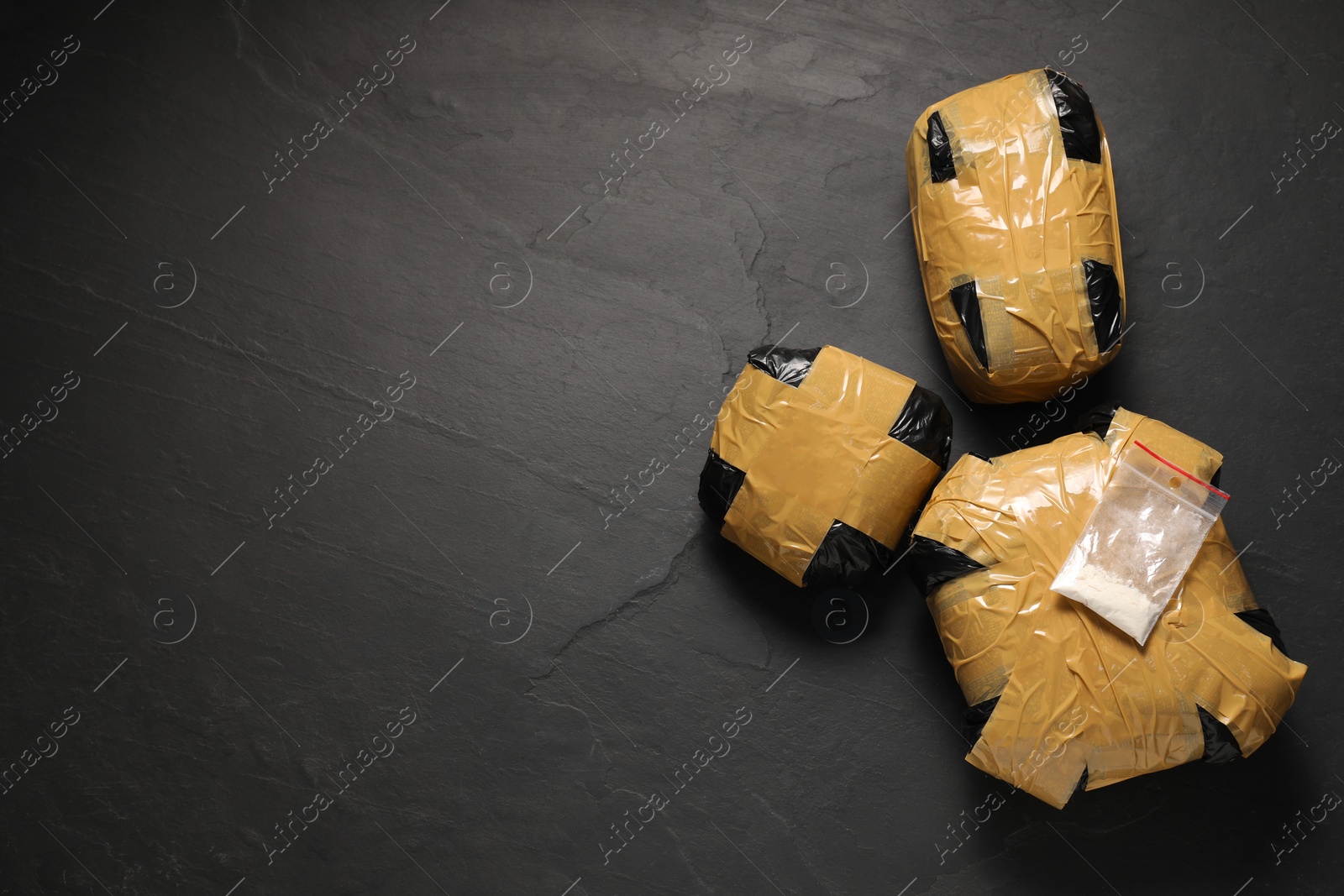 Photo of Packages with narcotics on black table, flat lay. Space for text