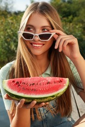 Photo of Beautiful girl with slice of watermelon outdoors