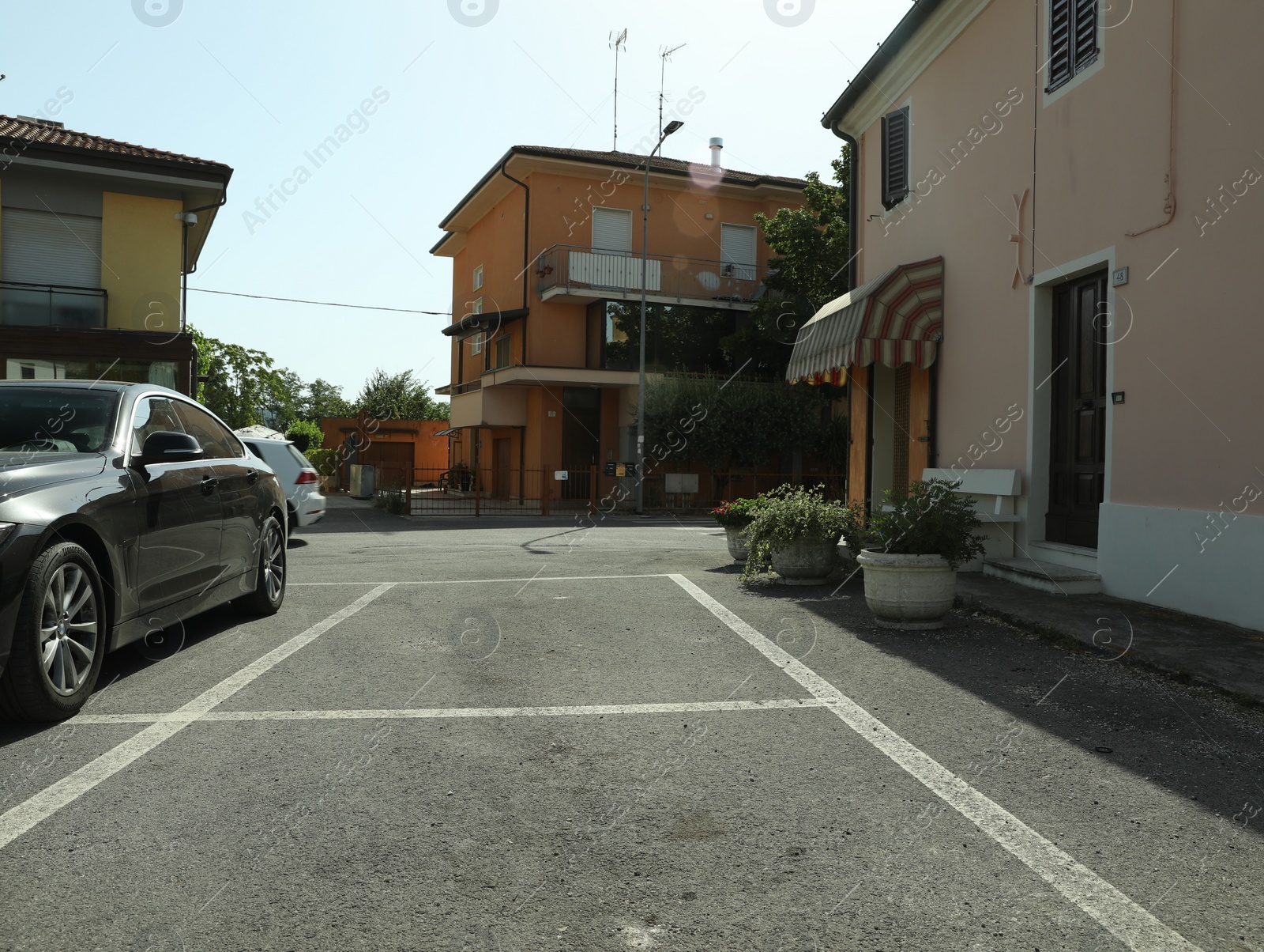 Photo of Beautiful street with parking lot and buildings on sunny day