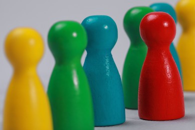 Photo of Colorful pawns on light grey background, closeup. Recruiter searching employee