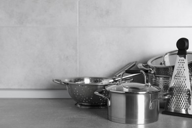 Photo of Set of different cooking utensils on grey countertop in kitchen. Space for text