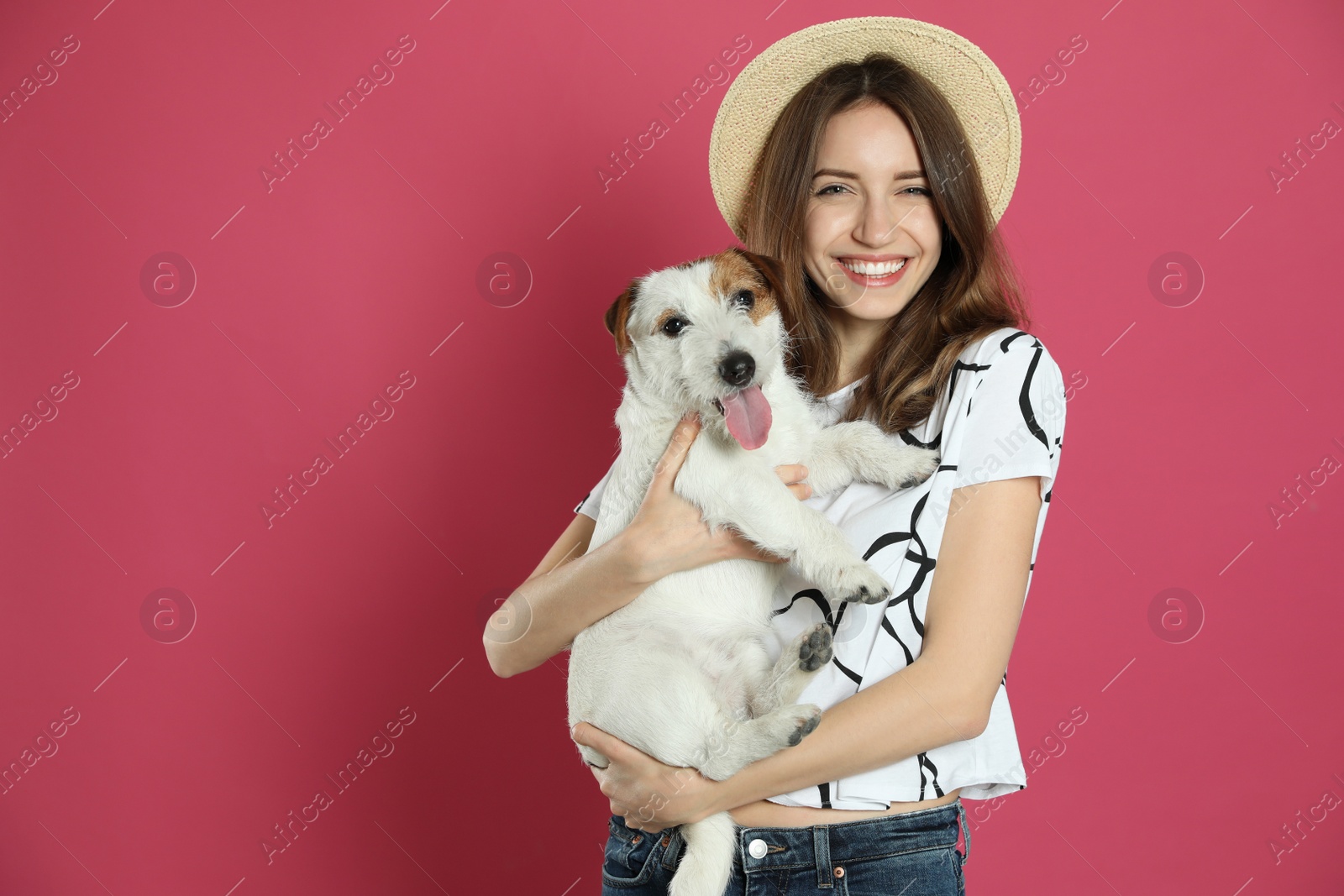 Photo of Young woman with her cute Jack Russell Terrier on pink background, space for text. Lovely pet