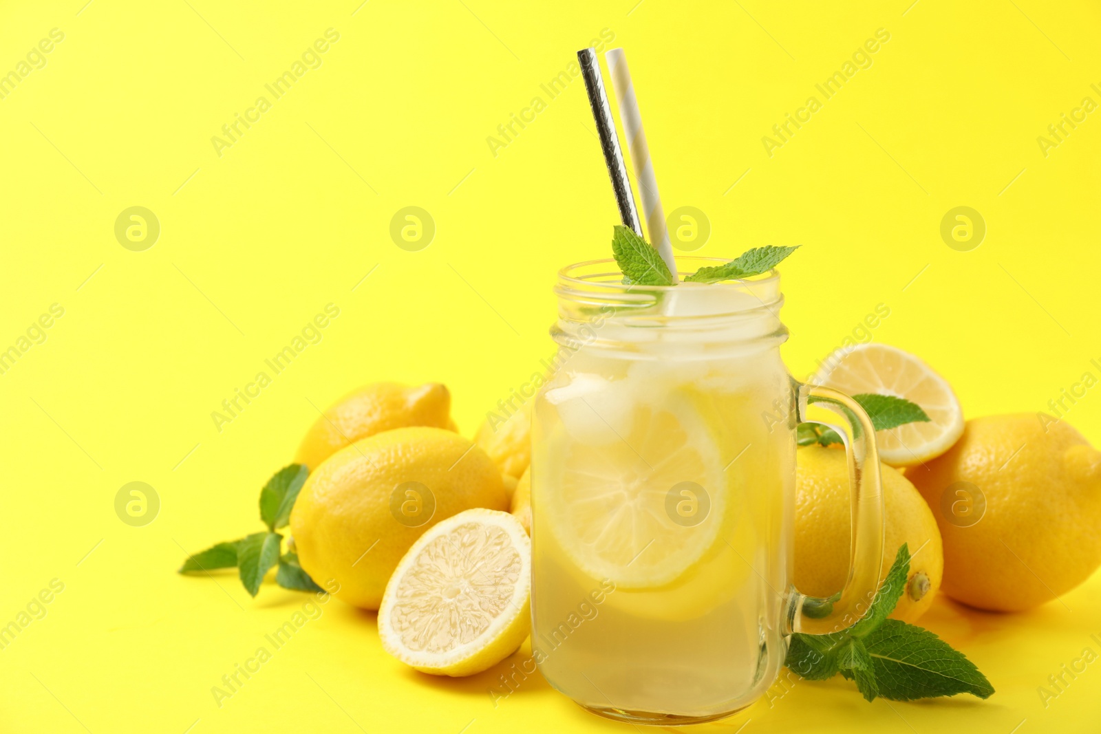 Photo of Freshly made natural lemonade on yellow background. Summer refreshing drink