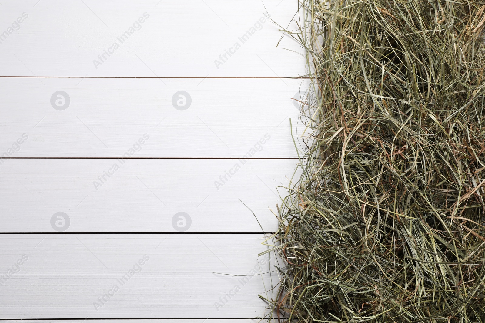 Photo of Heap of dried hay on white wooden table, top view. Space for text