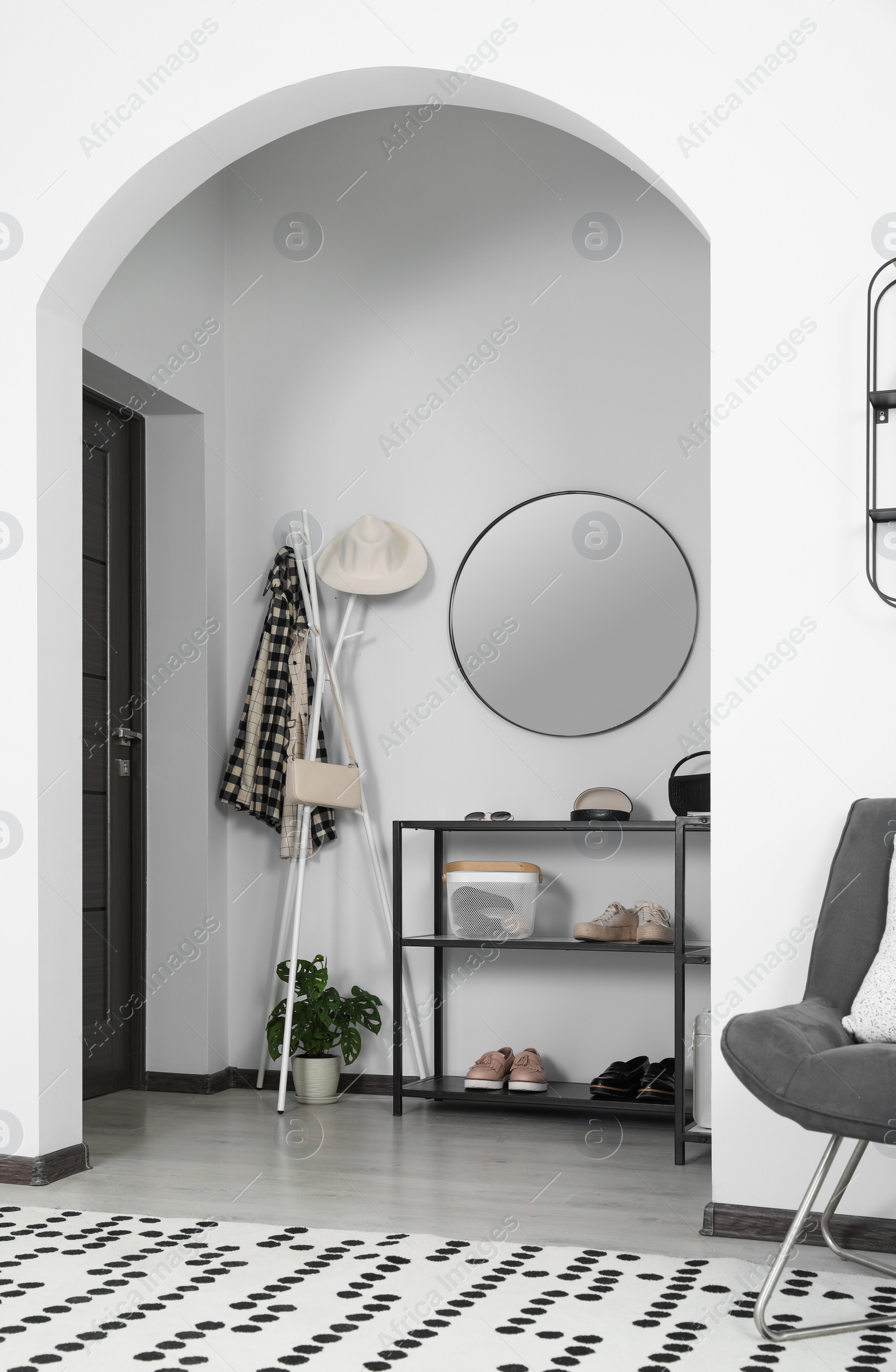 Photo of Hallway interior with stylish furniture and round mirror on light wall